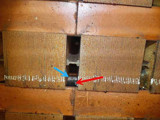 Figure 4: Slot partial discharge of a 13.8 kV generator. The red arrow indicates conductive tape (black), and the blue arrow indicates missing conductive tape from slot partial discharge. The white tape is the remaining armor tape.