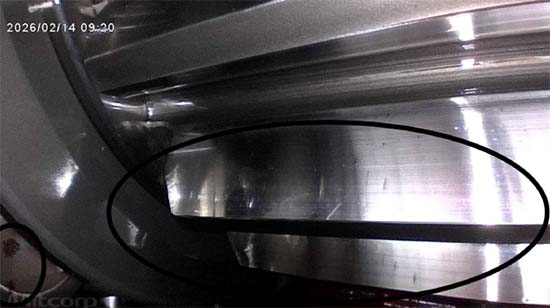 Figure 5.  A dark, sharply defined transverse line on the gear teeth, with particle accumulation visible at lower left.